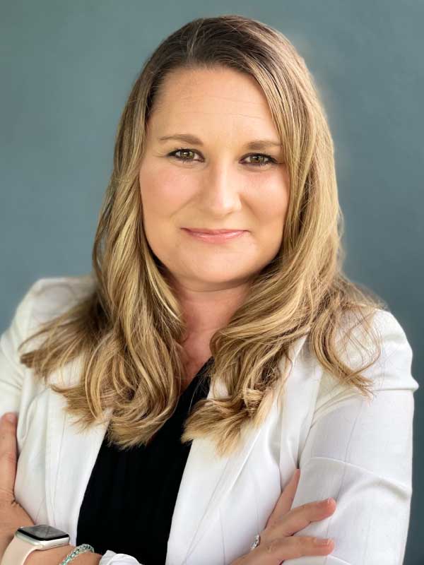 A photo of Crystal Crowell wearing a black blouse with a white blazer.