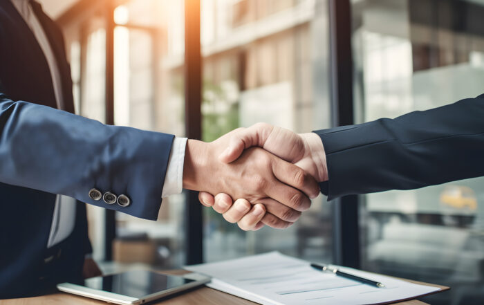 Business professionals shaking hands over a signed contract, symbolizing successful financial and accounting partnerships at LedgerLogix.
