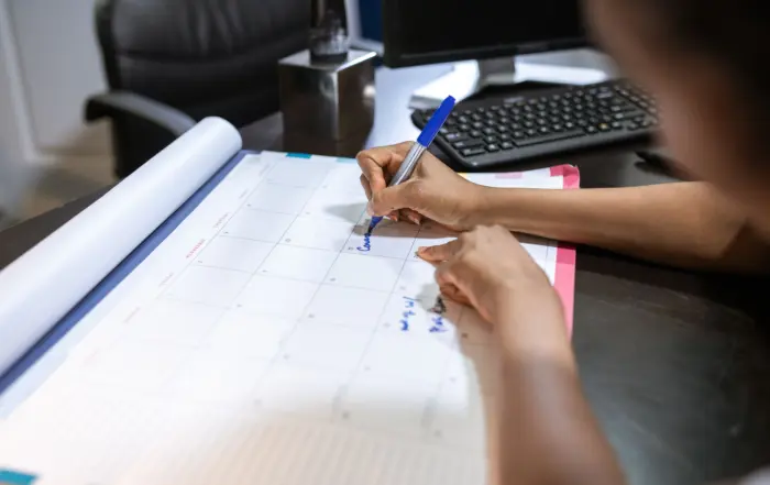 Hands Writing On Planning Grid
