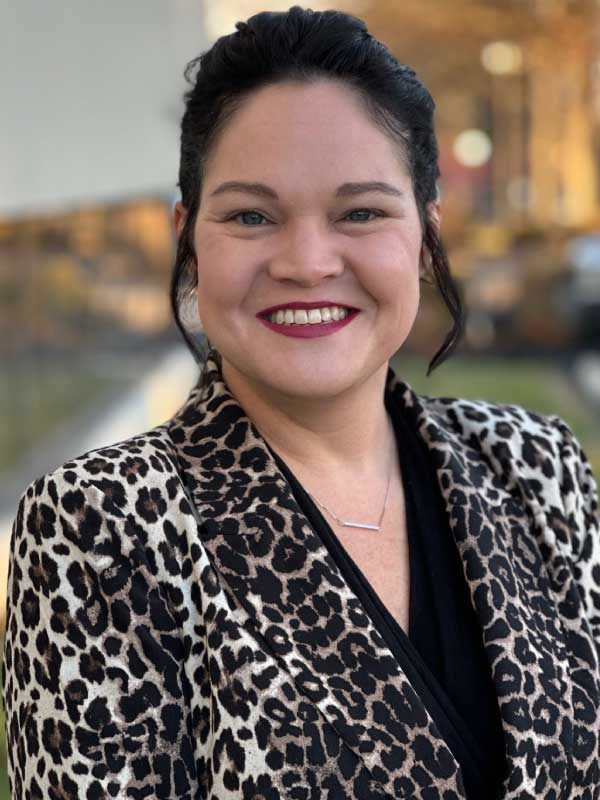 A photo of Rachel Blackburn wearing a leopard print blazer over a black top outside of TP4 Advisors office building.