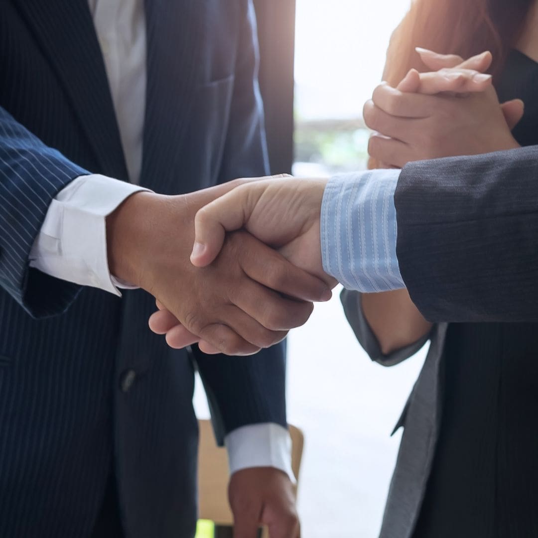 Two people shaking hands in an office setting